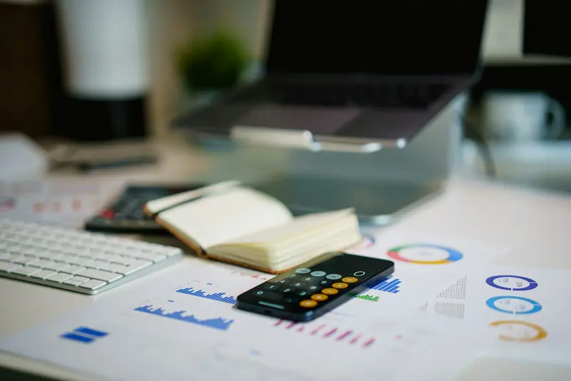 Phone and printed financial charts on a desk