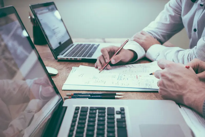 Planning figures on paper next to a laptop