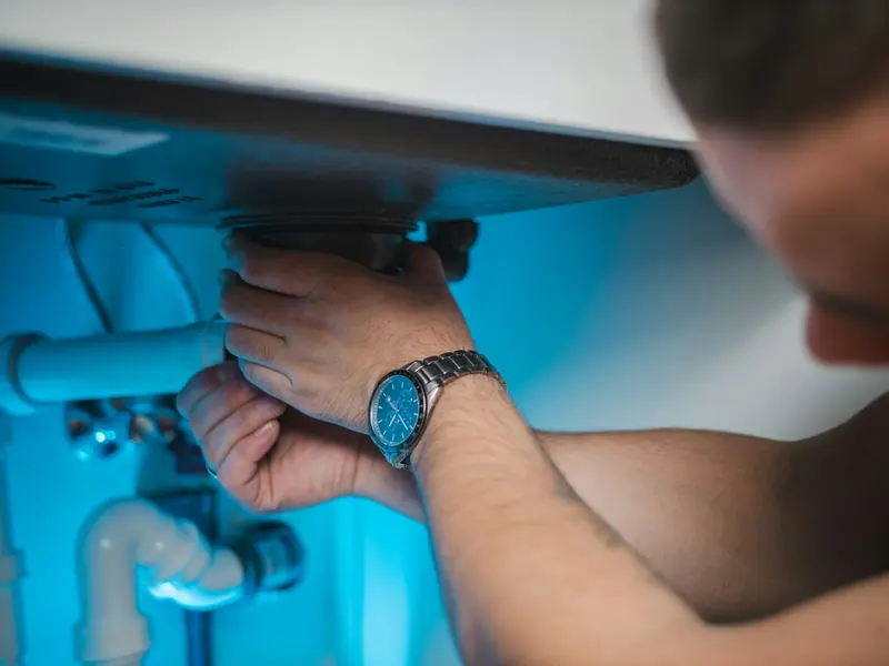 Plumber fitting a water heater in a utility room