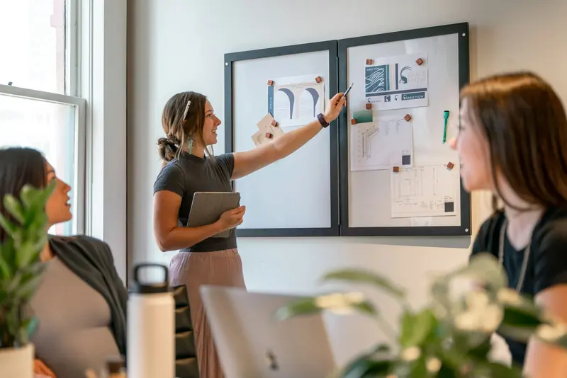Presenting a plan on a pin board to colleagues