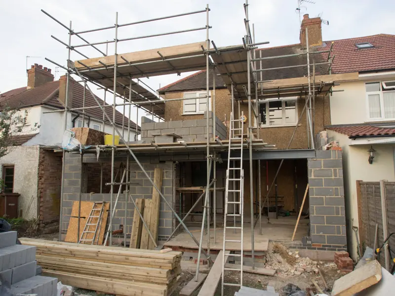 Rear extension under construction with scaffold, ladders and timber stacked in the garden