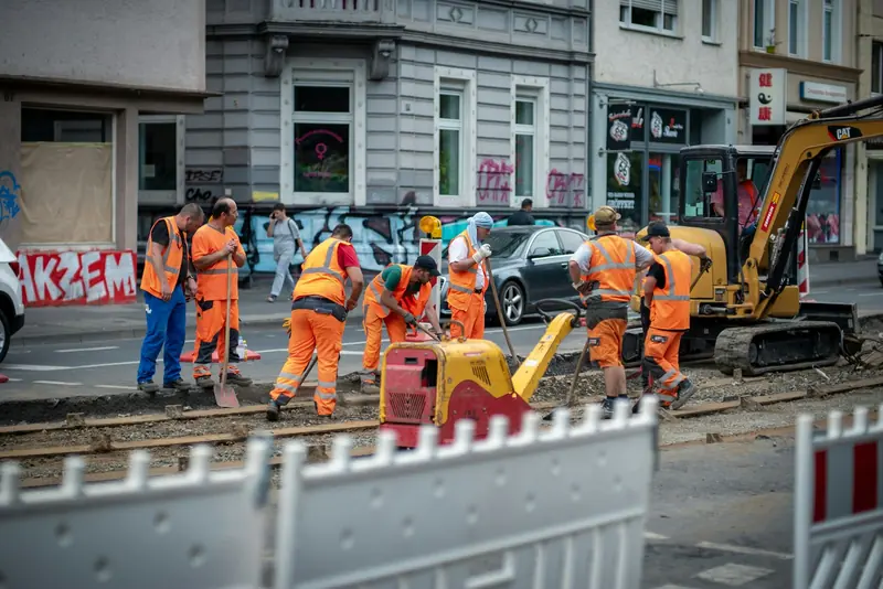 Road crew in orange hi-vis working on a city street dig