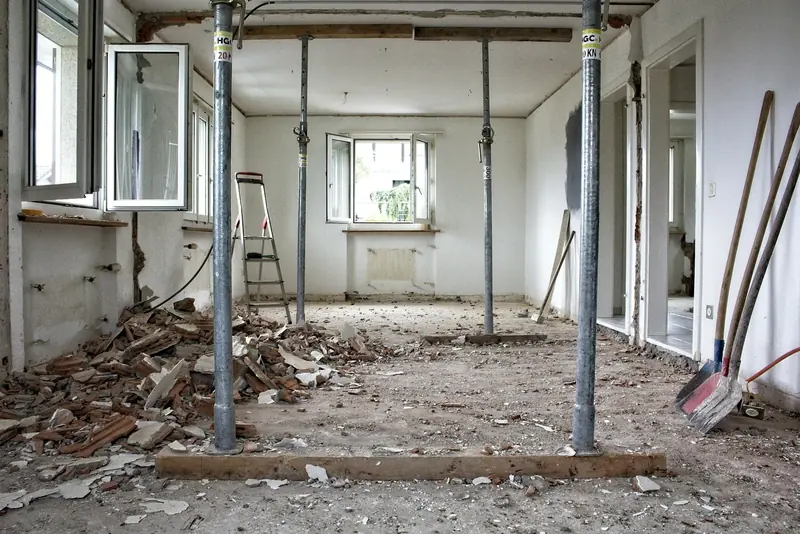 Room under renovation with steel props, debris and tools