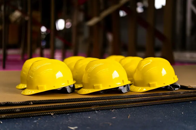 Row of new yellow hard hats laid out ready for site induction