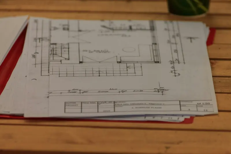 Sets of construction drawings spread across a site table