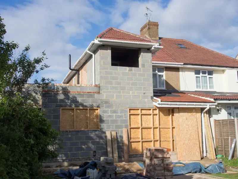 Side and rear extension in blockwork with boarded window openings