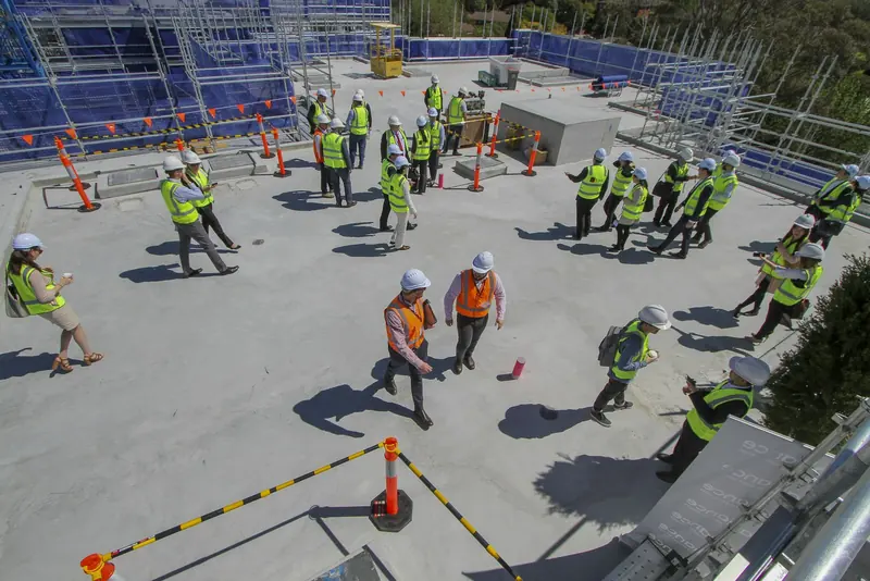 Site team in hi-vis gathered for a briefing on a concrete deck