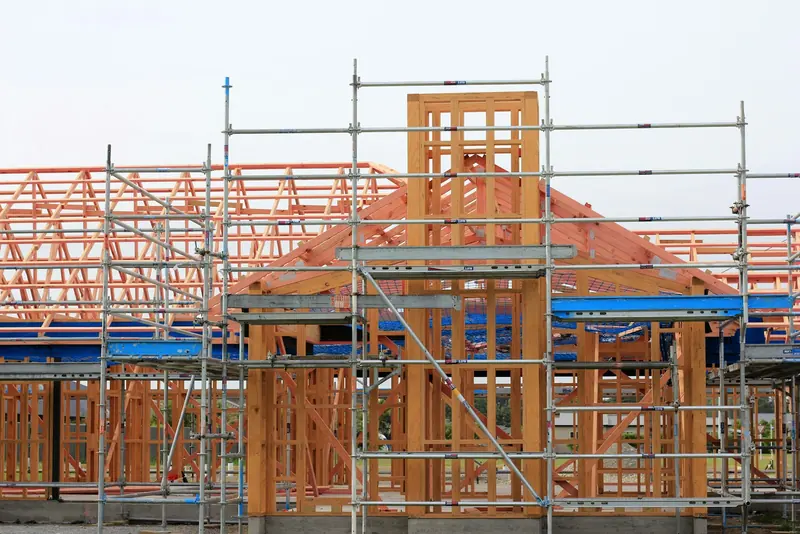 Timber-frame house with roof trusses inside scaffold