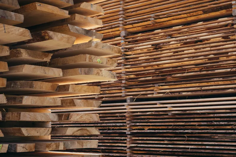 Stacked timber lengths at a builders' merchant yard