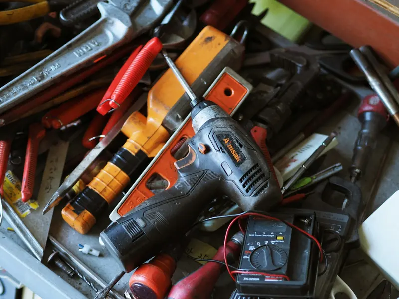 Toolbox full of power tools, screwdrivers and a multimeter