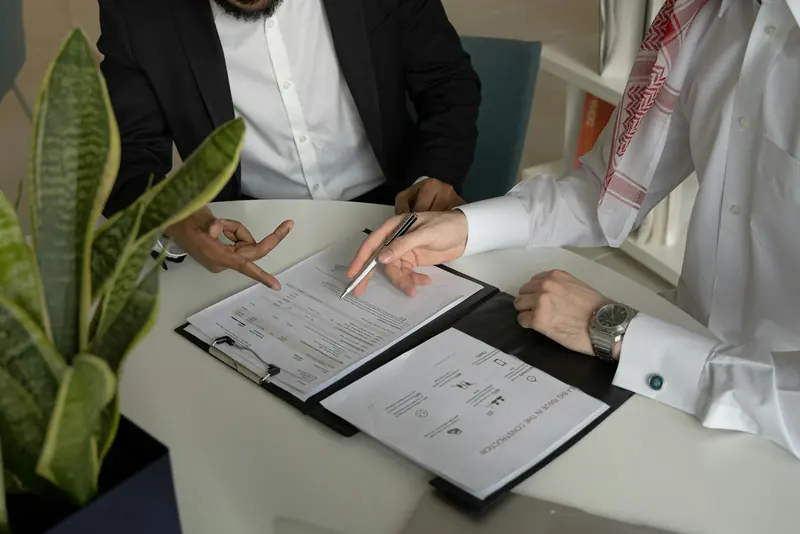 Two men going through papers at a table