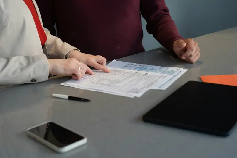 Two people reviewing documents at a meeting table