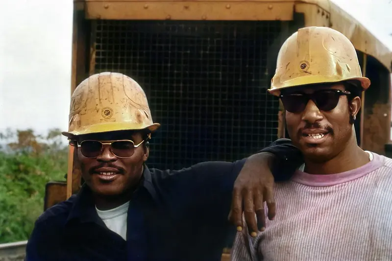 Two site workers in hard hats standing together on site