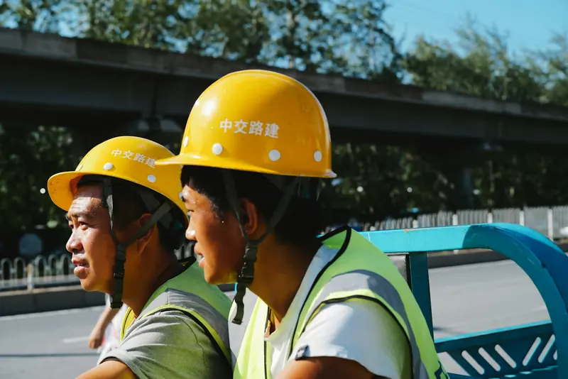 Two workers in yellow hard hats taking a break on site
