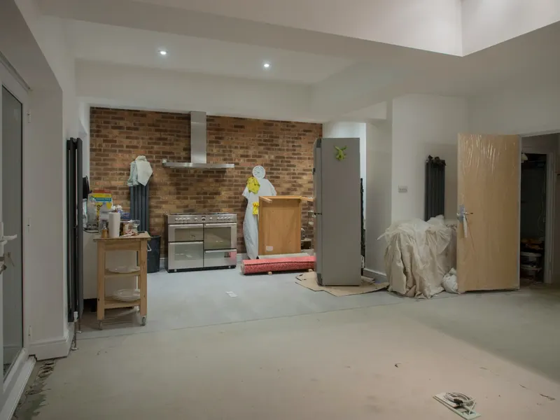 Unfinished kitchen with exposed brick walls during a renovation