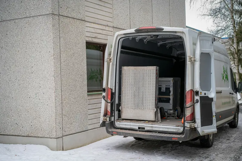 Van with the back doors open, loaded with materials