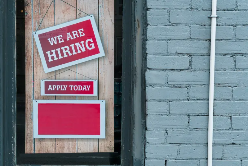 We are hiring sign hung on a door