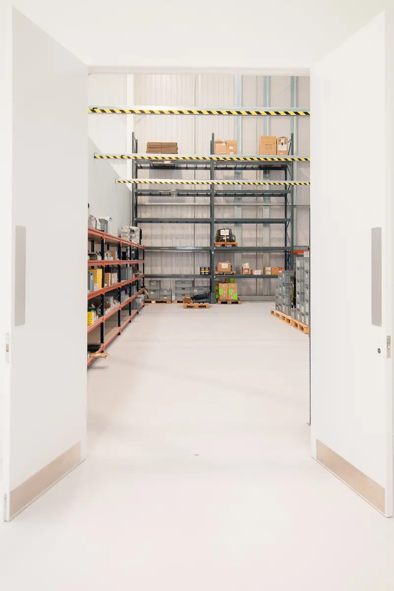 Storage room with steel shelving and a white resin floor